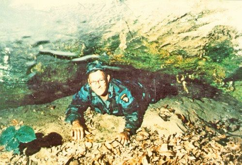 Russell Eugene Burrows en la entrada a la cueva que descubrió