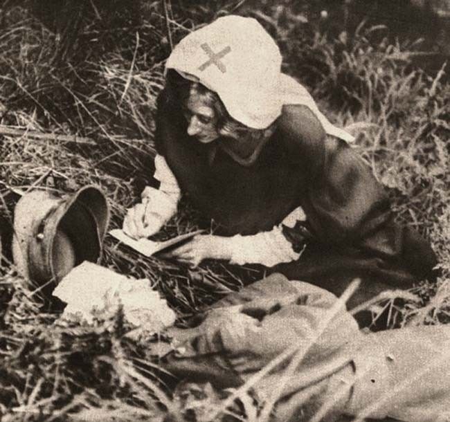 © Paul Thompson   
Enfermera de la Cruz Roja escribe las últimas palabras de un herido de un soldado herido de muerte. 1917