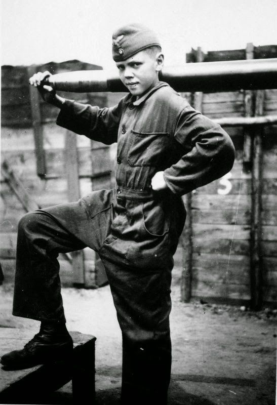Desconocido joven artillero antiaéreo alemán 'flakhelfer' en posición con un proyectil antiaéreo 8.8 cm FlaK 18/41 en la ciudad alemana de Hagen (Hagen). Innumerables bombarderos estadounidenses fueron derribados por chicos como este. Estos valientes muchachos estaban a la intemperie mientras las bombas caían a su alrededor. ¿Alguno de estos muchachos murió haciendo eso? Si
