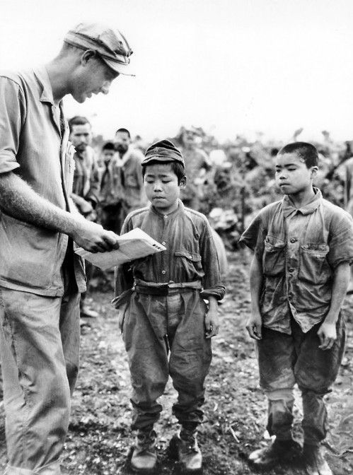 El primer teniente de la Marina de los EE. UU. Hart H. Spiegal intenta comunicarse con dos niños soldados japoneses capturados durante la batalla de Okinawa. 17 de junio de 1945